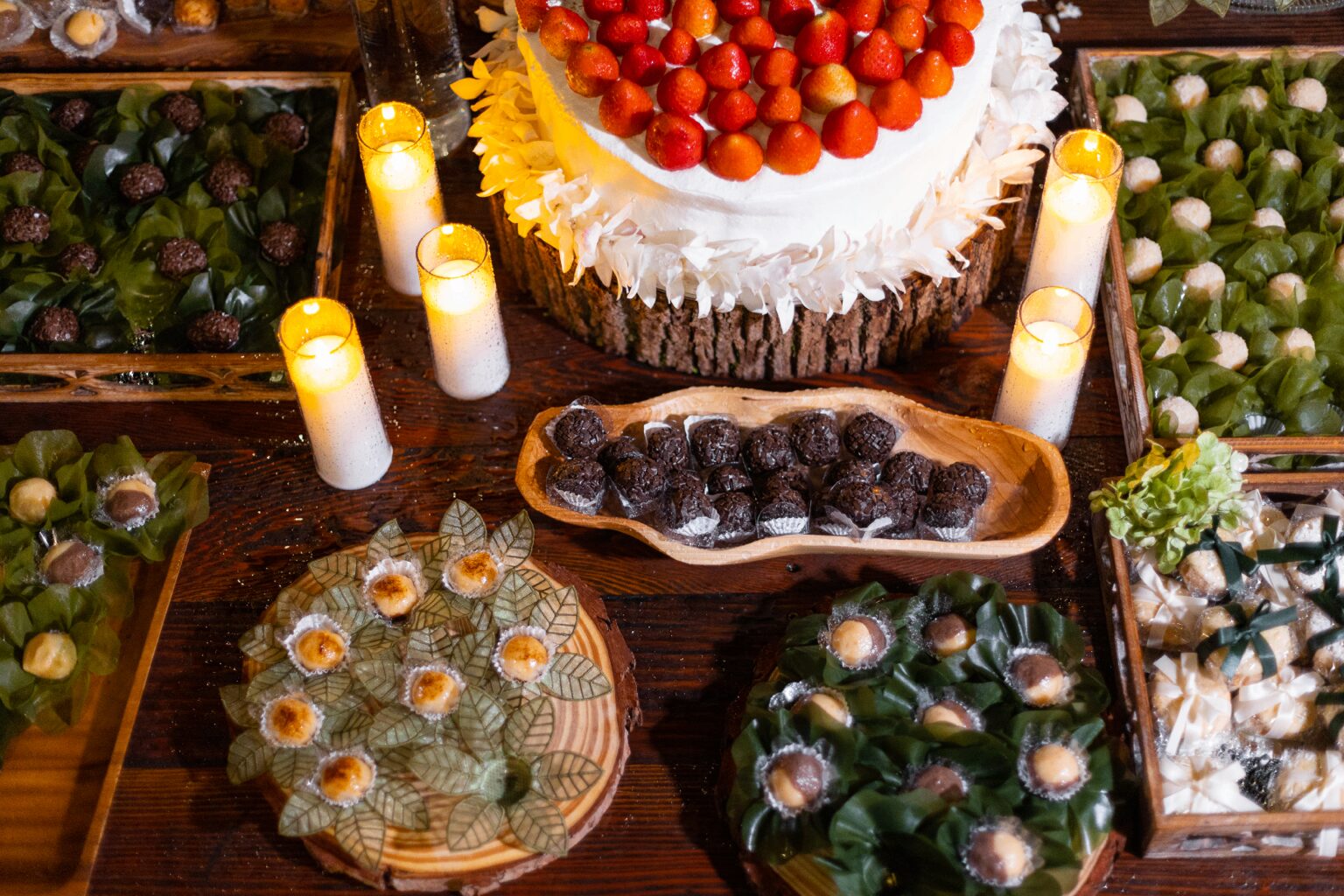 Mesa de doces rústica com bolo de morangos Mesa de doces rústica com bolo de morangos, brigadeiros e velas acesas